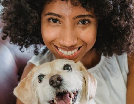 happy black woman embracing funny dog