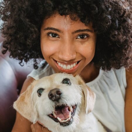 happy black woman embracing funny dog