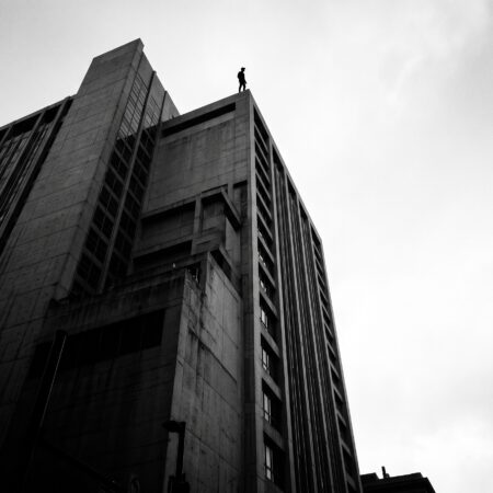 A vulnerable person atop a large concrete building